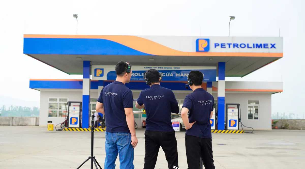 Ekip dựng máy quay trước mái che cửa hàng xăng dầu Petrolimex